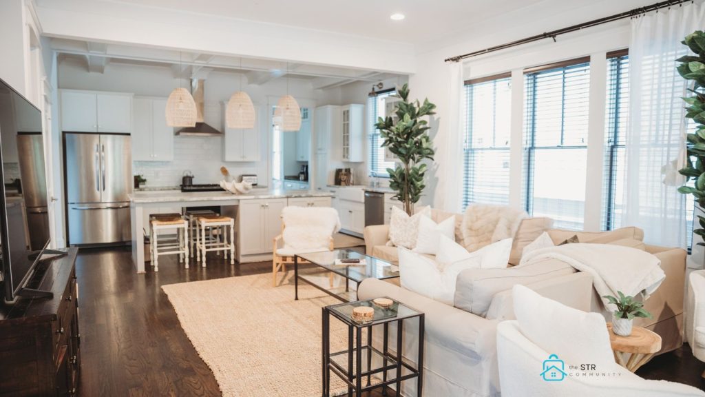 Bright, modern short-term rental living room with open kitchen, styled for guest comfort and efficiency